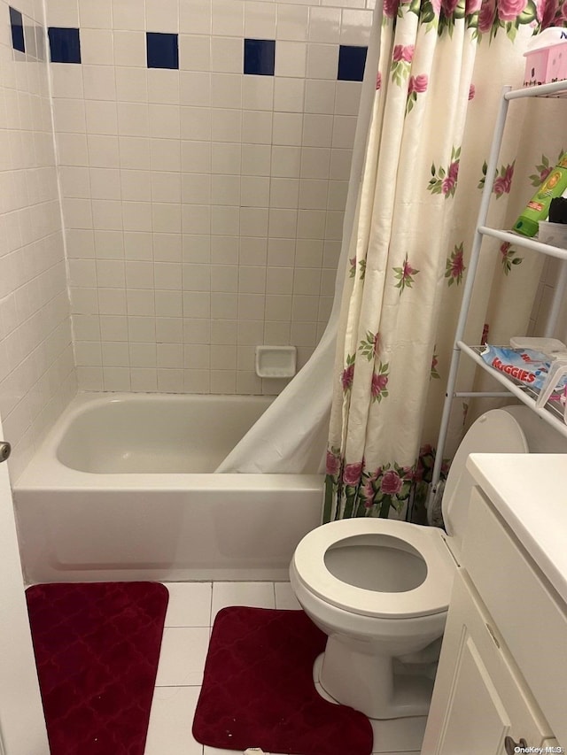 bathroom with tile patterned floors, toilet, and shower / bath combo with shower curtain