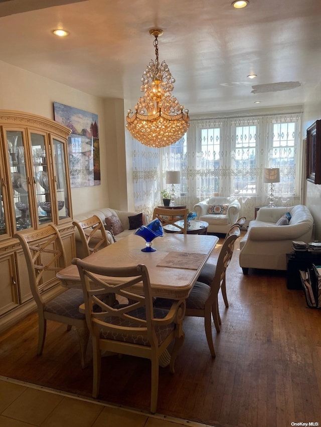 dining space with hardwood / wood-style flooring, a healthy amount of sunlight, and a chandelier