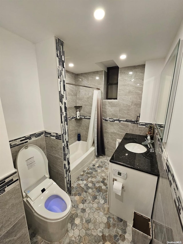 full bathroom with tile patterned floors, vanity, shower / bath combo with shower curtain, tile walls, and toilet