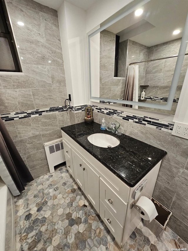 bathroom featuring vanity, tile walls, and radiator