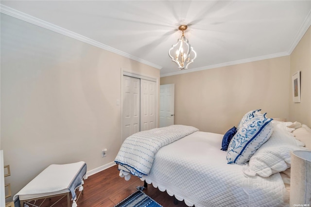 bedroom featuring dark hardwood / wood-style floors, an inviting chandelier, ornamental molding, and a closet