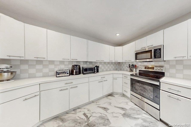 kitchen featuring white cabinets, appliances with stainless steel finishes, and tasteful backsplash