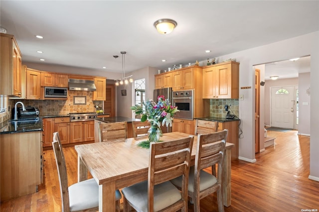 dining area with sink and light hardwood / wood-style floors