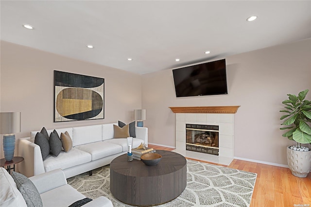 living room featuring hardwood / wood-style floors and a tiled fireplace