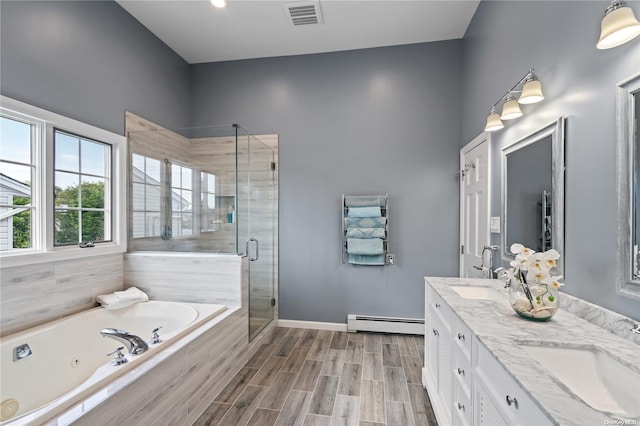 bathroom with a baseboard radiator, vanity, and independent shower and bath