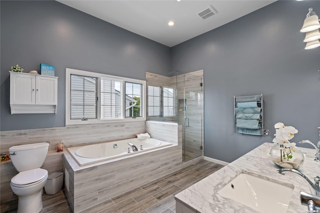 full bathroom featuring independent shower and bath, toilet, and vanity