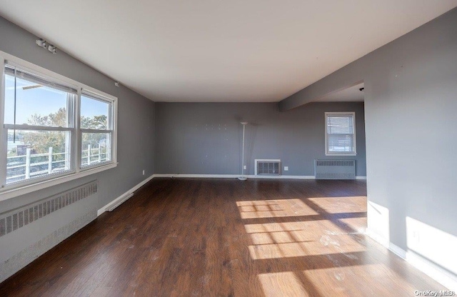 spare room with wood-type flooring and radiator