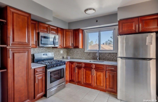 kitchen featuring tasteful backsplash, sink, light tile patterned floors, and stainless steel appliances