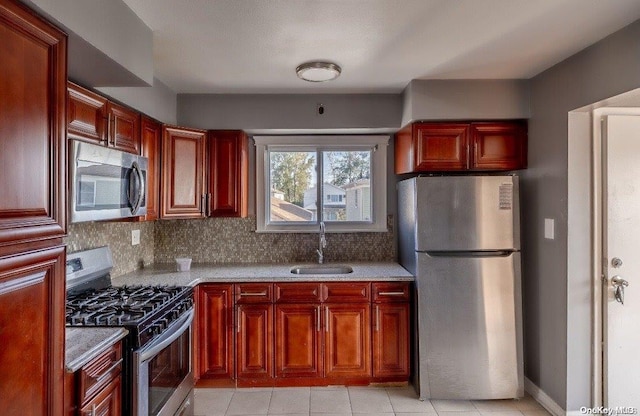 kitchen with sink, stainless steel appliances, light stone counters, decorative backsplash, and light tile patterned flooring