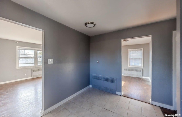 empty room with radiator heating unit and light wood-type flooring