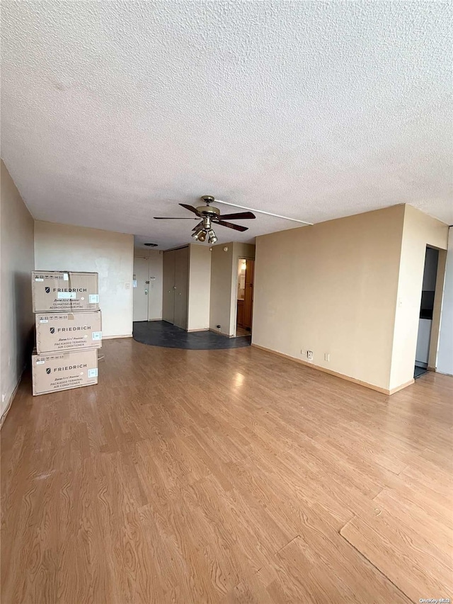 unfurnished living room featuring a textured ceiling, light hardwood / wood-style flooring, and ceiling fan