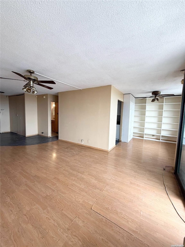 spare room featuring wood-type flooring, a textured ceiling, and ceiling fan