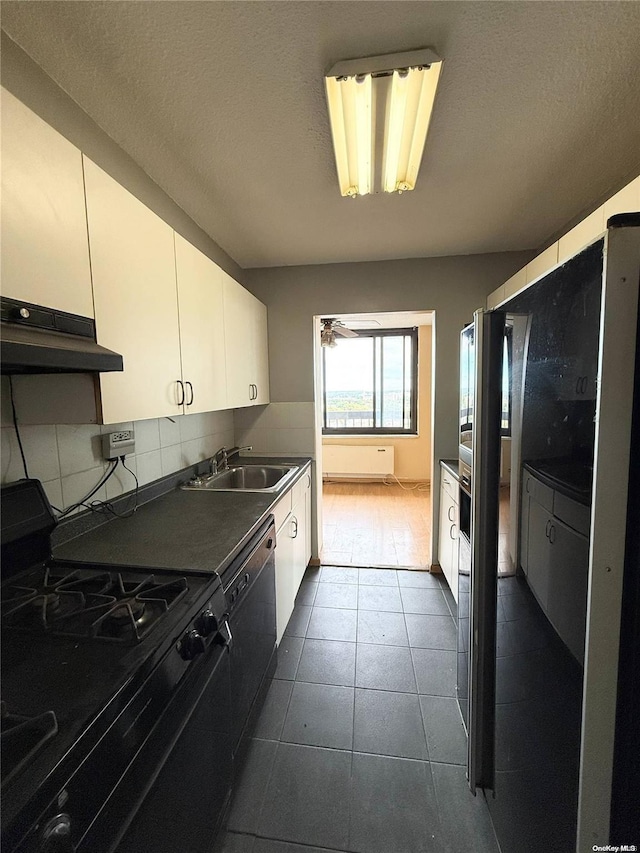 kitchen featuring white cabinetry, sink, backsplash, a textured ceiling, and black appliances