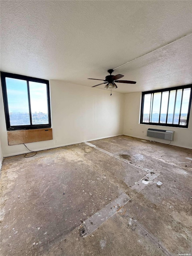 unfurnished room featuring a textured ceiling, ceiling fan, and a healthy amount of sunlight