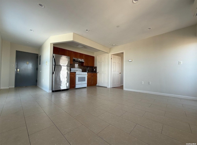 kitchen featuring stainless steel fridge, backsplash, white range oven, and light tile patterned floors