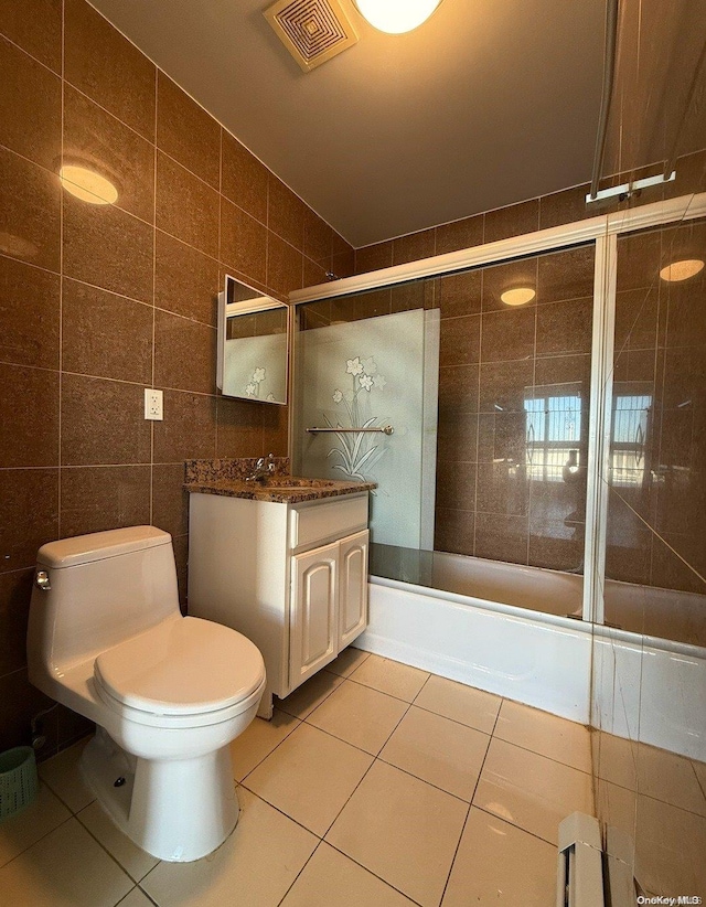 full bathroom with tile patterned floors, vanity, shower / bath combination with glass door, tile walls, and toilet