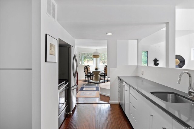 707 Pleasure Dr, Flanders, NY 11901 - kitchen featuring a sink, white cabinetry, appliances with stainless steel finishes, dark wood-style flooring, and baseboards