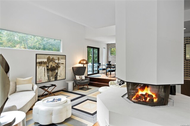 707 Pleasure Dr, Flanders, NY 11901 - living area with a multi sided fireplace and wood finished floors