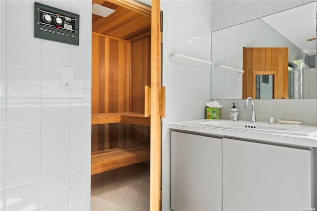 bathroom featuring tile patterned floors, vanity, and tile walls