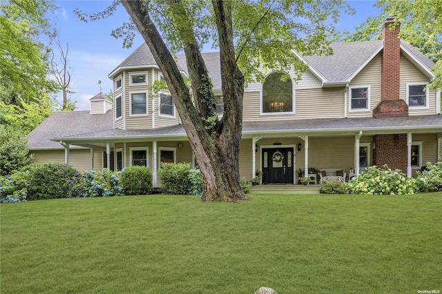 victorian-style house featuring covered porch and a front yard