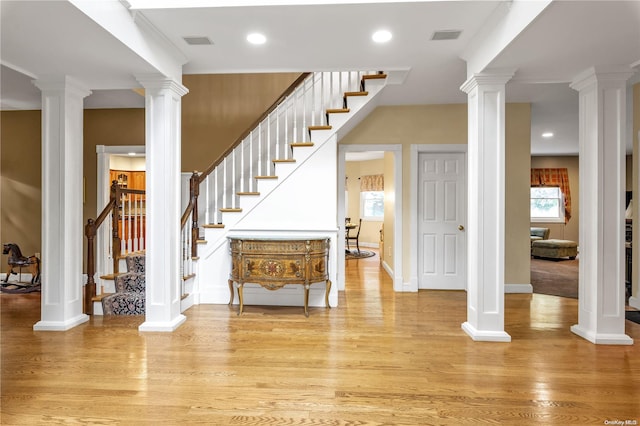 entryway with decorative columns and light hardwood / wood-style flooring