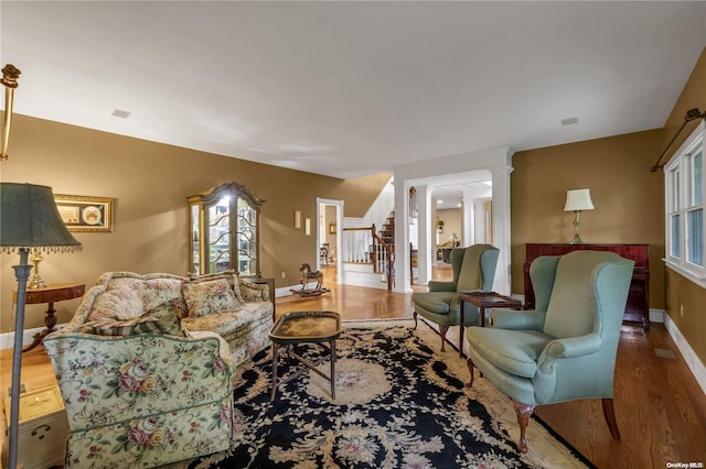 living room with hardwood / wood-style floors and decorative columns