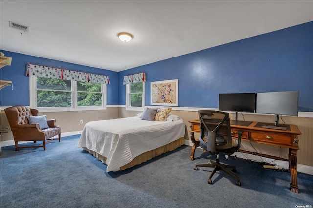 bedroom with carpet floors and wooden walls