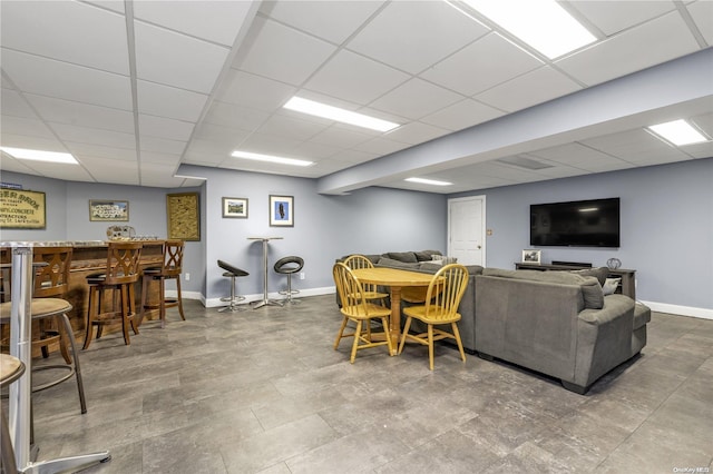 living room with a drop ceiling and indoor bar