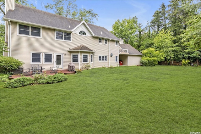 rear view of house featuring a yard and a deck