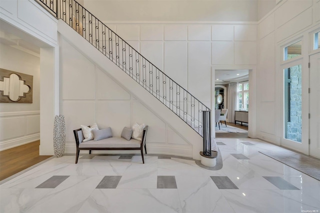 entrance foyer featuring a high ceiling and crown molding