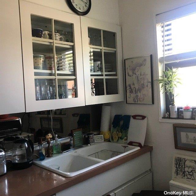 interior space with white cabinetry and sink