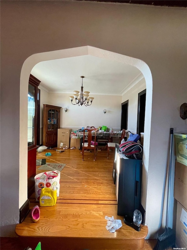 dining room featuring crown molding, a chandelier, and hardwood / wood-style flooring