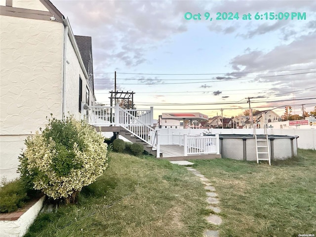 yard at dusk with a swimming pool side deck