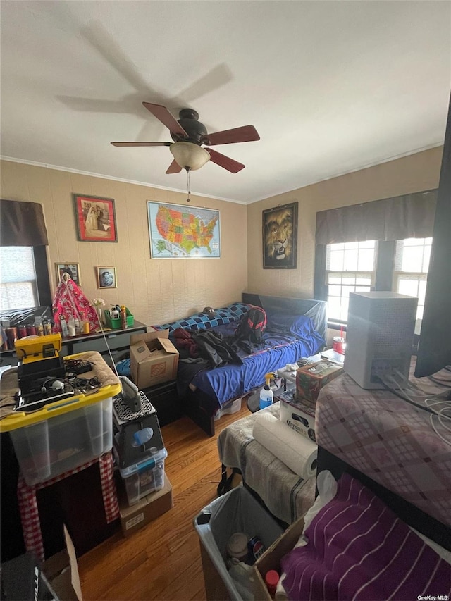 bedroom featuring hardwood / wood-style flooring, ceiling fan, and ornamental molding