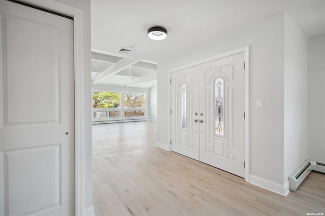 foyer featuring light wood-type flooring and a baseboard heating unit