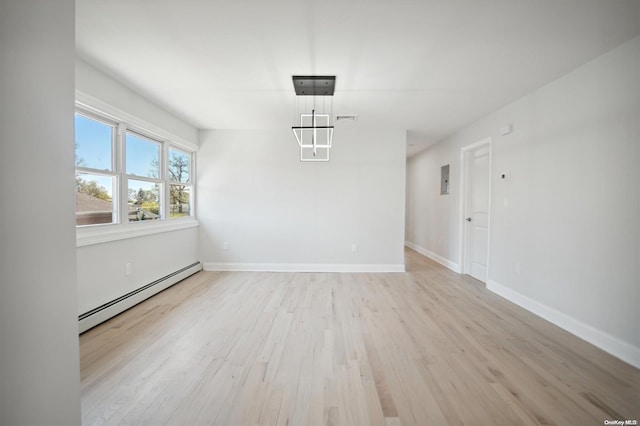 unfurnished dining area with light wood-type flooring and a baseboard heating unit