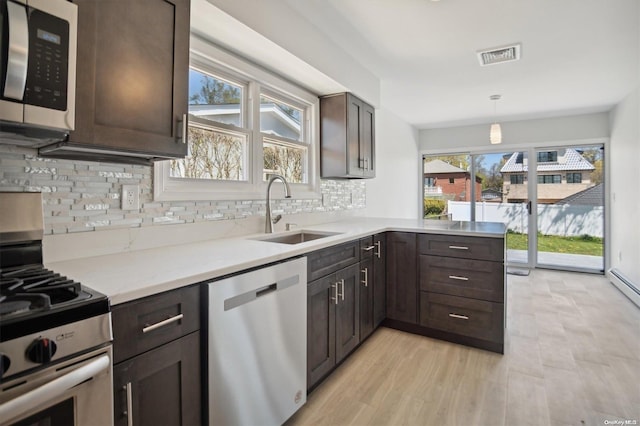 kitchen featuring pendant lighting, stainless steel appliances, a healthy amount of sunlight, and sink