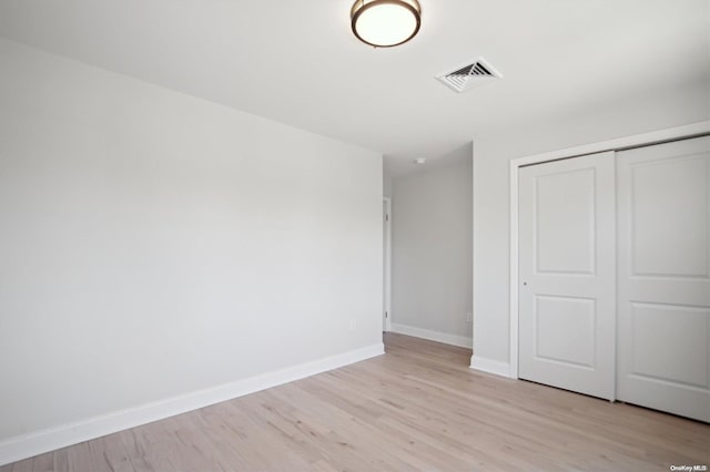 unfurnished bedroom featuring light hardwood / wood-style floors and a closet