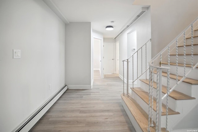 hallway with light hardwood / wood-style flooring and a baseboard radiator