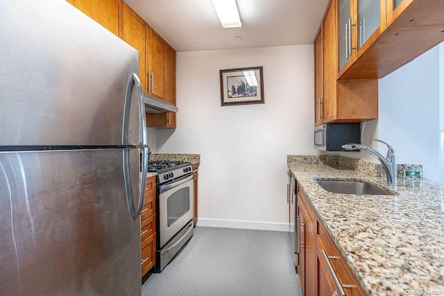 kitchen featuring light stone countertops, appliances with stainless steel finishes, and sink