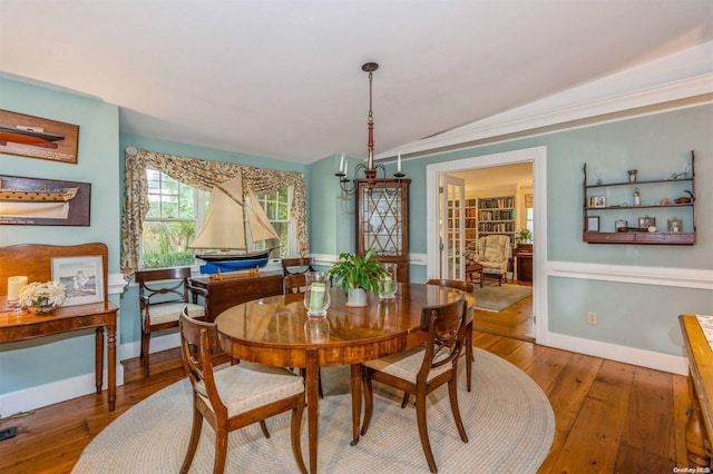 dining area with crown molding, hardwood / wood-style floors, and vaulted ceiling