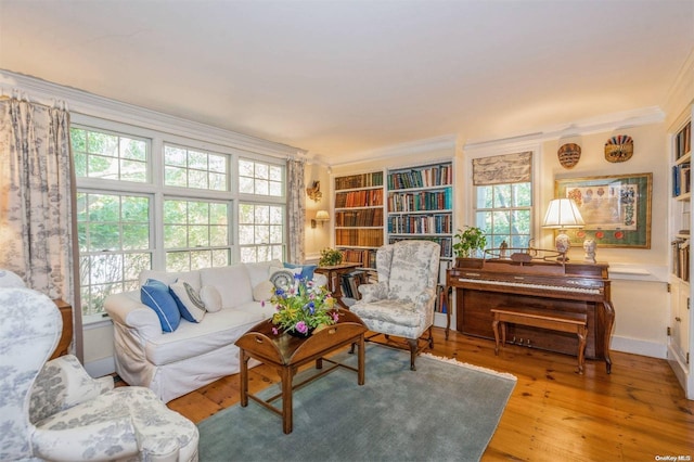 living room featuring hardwood / wood-style flooring, a healthy amount of sunlight, and ornamental molding