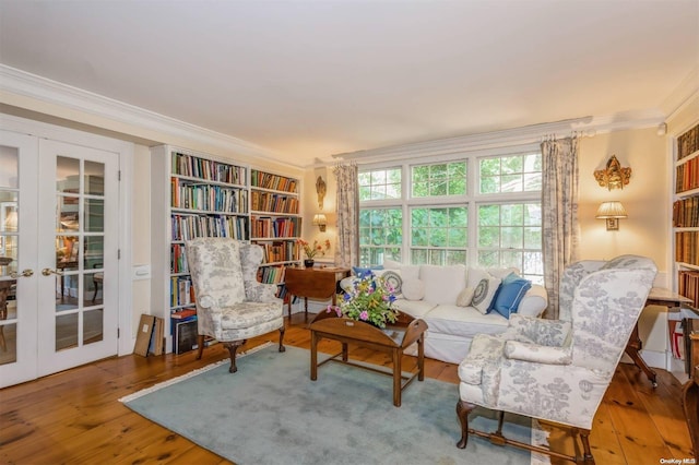 living area featuring hardwood / wood-style flooring, crown molding, and french doors