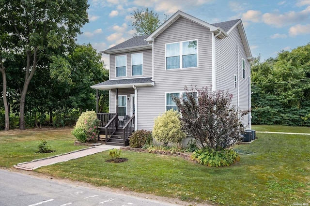 view of front of property with central air condition unit and a front lawn