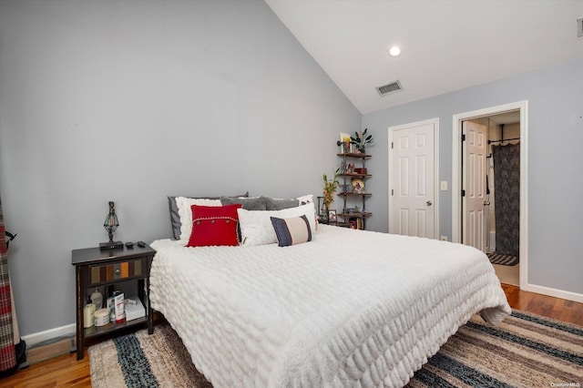 bedroom with hardwood / wood-style flooring and lofted ceiling