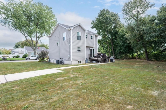 rear view of house with a yard and central AC unit