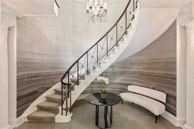 stairs with tile patterned flooring and a notable chandelier