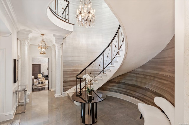 staircase featuring decorative columns and ornamental molding