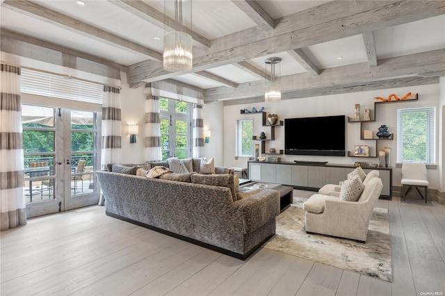 living room with plenty of natural light, light hardwood / wood-style floors, beam ceiling, and french doors