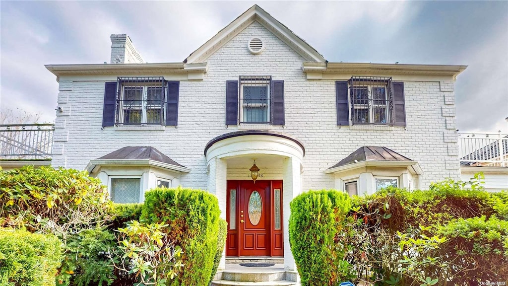 110-56 68th Ave, Forest Hills, NY 11375 - view of front of house featuring brick siding and a chimney